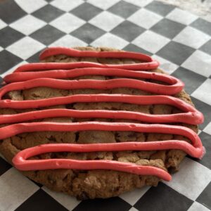 Giant 5.5″ Round Peanut Butter Cup Cookie Drizzled with Strawberry Flavored White Chocolate  Made to order needs 48 hour Notice